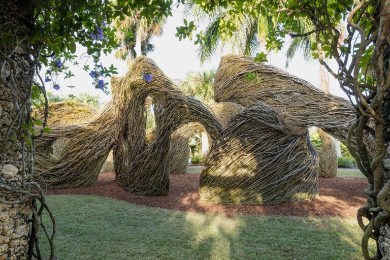 Weaving sticks create an undulating structure that imitates the rise and fall of waves.