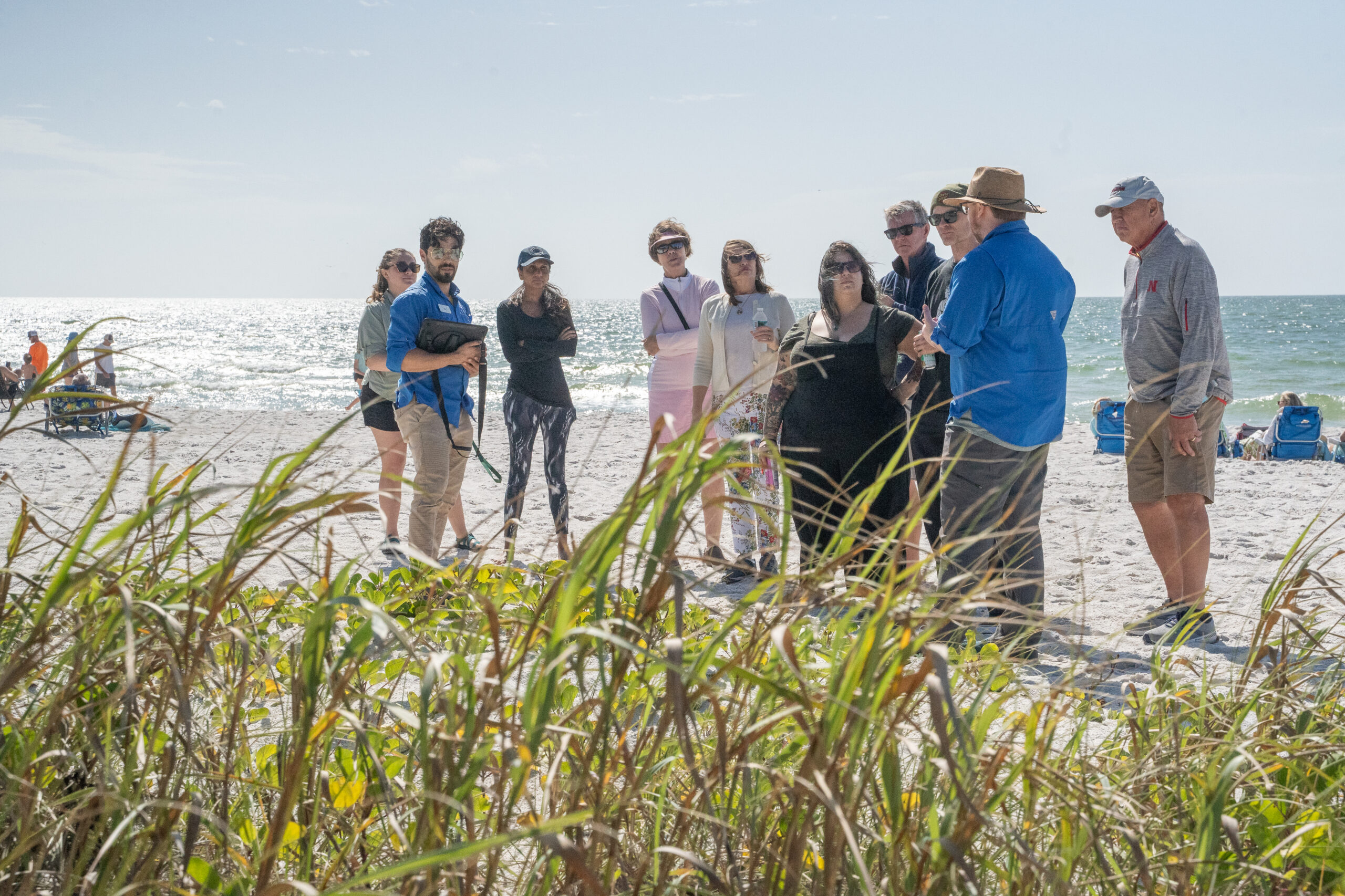 Two Garden educators speak to a group of guests about beach dune plants at Naples beach.