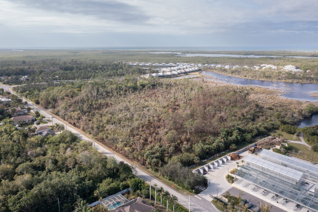 An aerial image shows a section of Naples Botanical Garden Preserve, surrounding housing developments, and the Gulf beyond. 