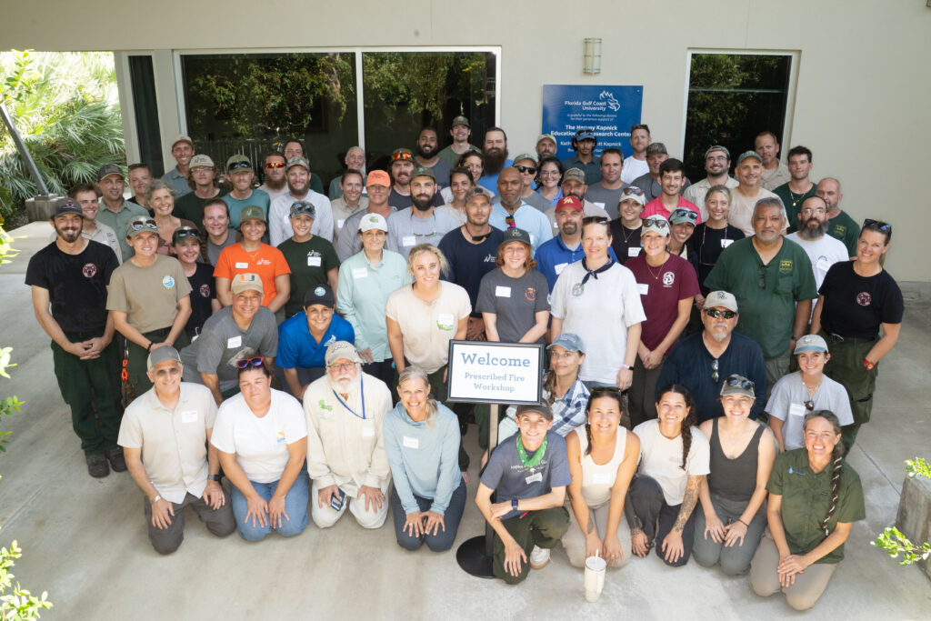 A large group of about 80 people all pose together for a group photo.