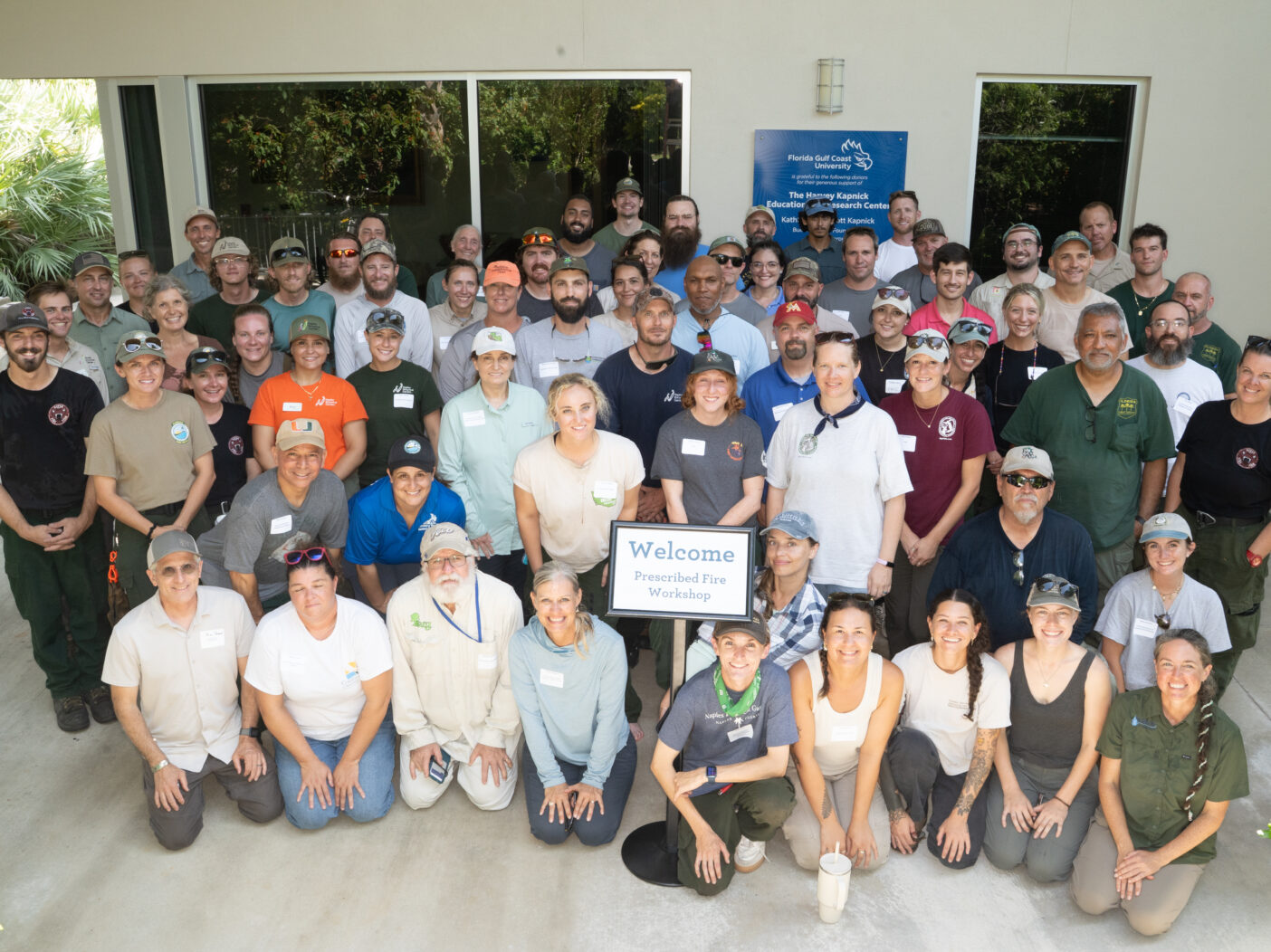 A large group of about 80 people all pose together for a group photo.