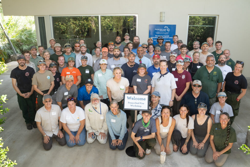 A large group of about 80 people all pose together for a group photo.